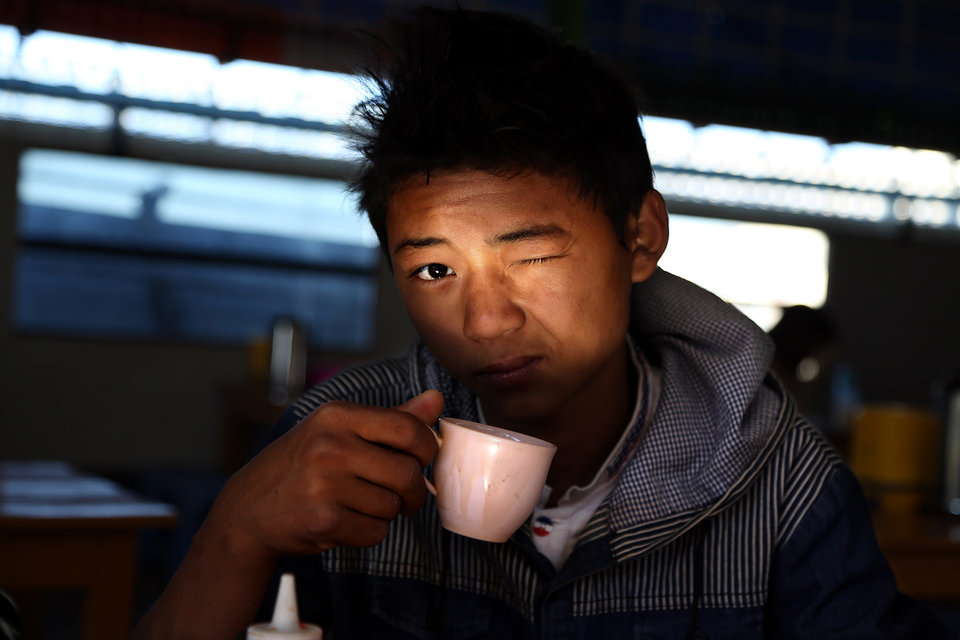 食堂でコーヒーをすする少年