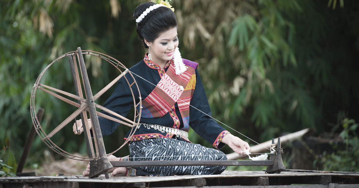 糸車で糸を紡ぐタイ人女性