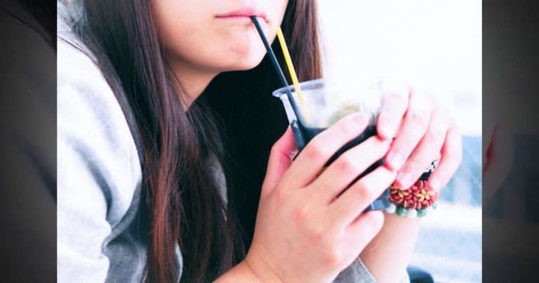 ストローでドリンクを飲む女性