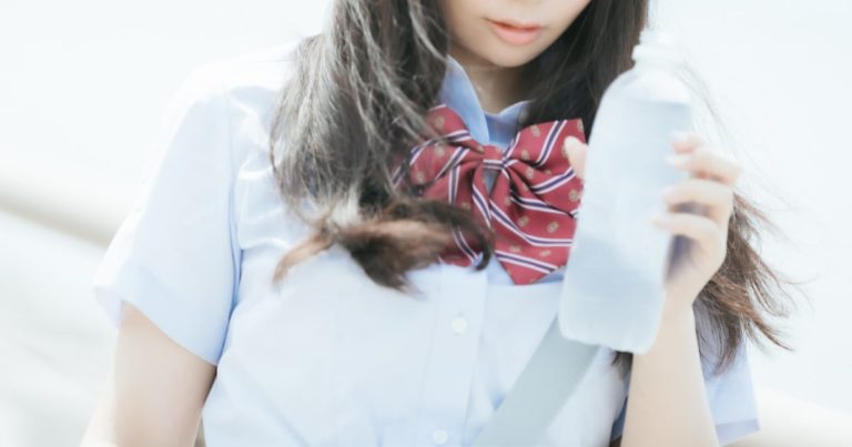 ペットボトルを持つ女子高生
