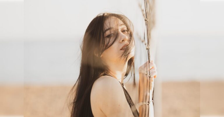 砂浜で金網を持つ外国人美女