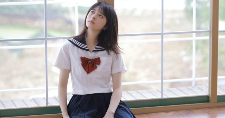 窓にもたれる女子高生