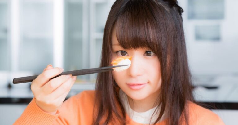 寿司を持って見つめる美少女