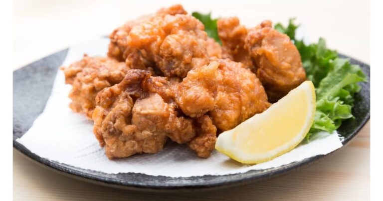 お皿に盛りつけされた鶏の唐揚げとレモン