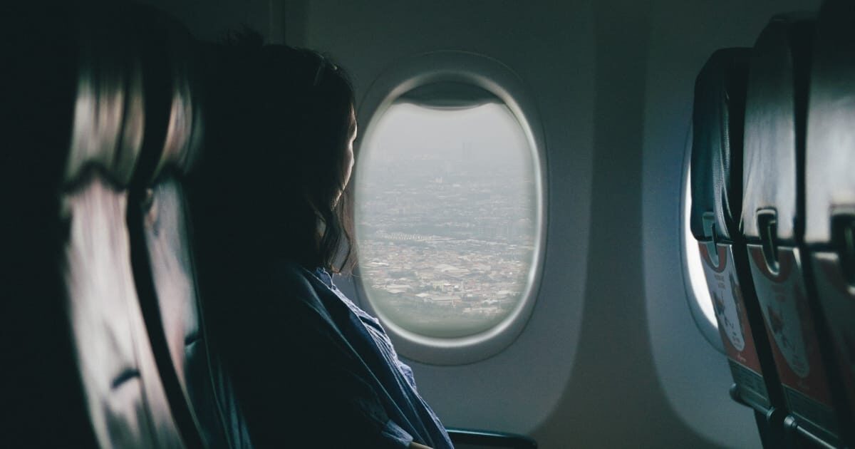 飛行機の外を眺める女性