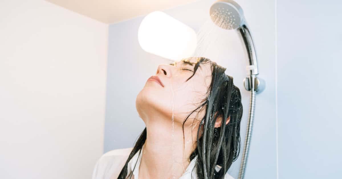 シャワーを顔から浴びる女性