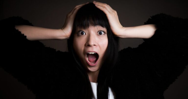 頭を抱えて叫ぶ女性