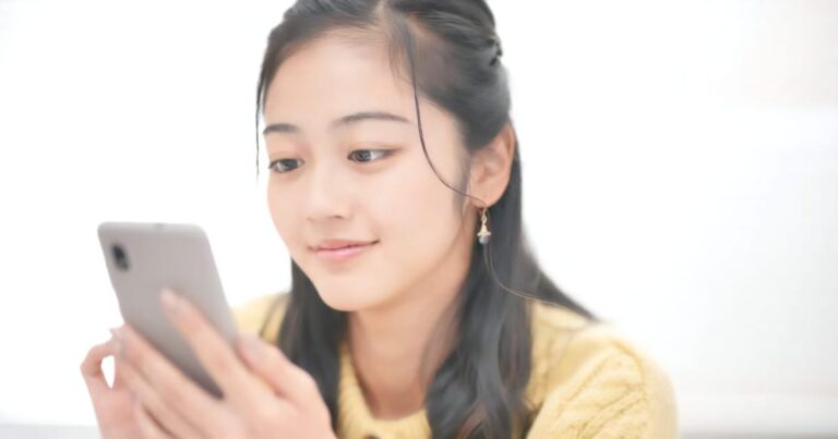 スマホをいじる美女