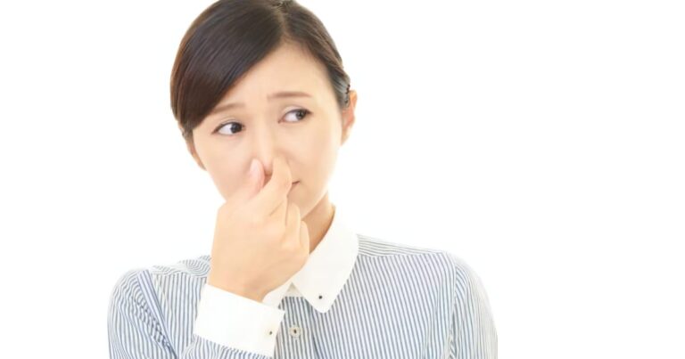 鼻をつまむ女性