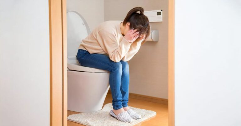 トイレで頭を抱える女性