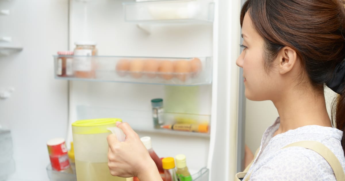冷蔵庫に何かを入れる女性