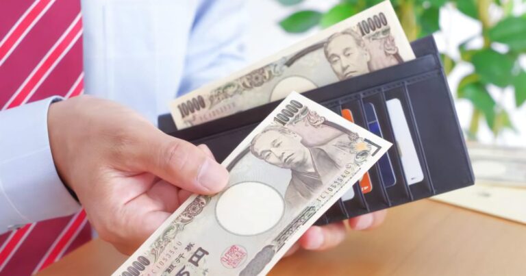 長財布から1万円を出すサラリーマン