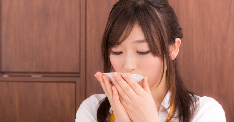 お味噌汁の味見をしている若妻
