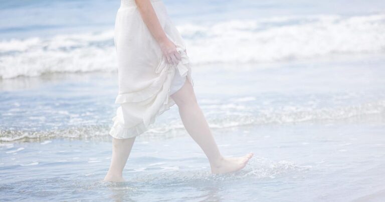 海岸を歩く女性の足